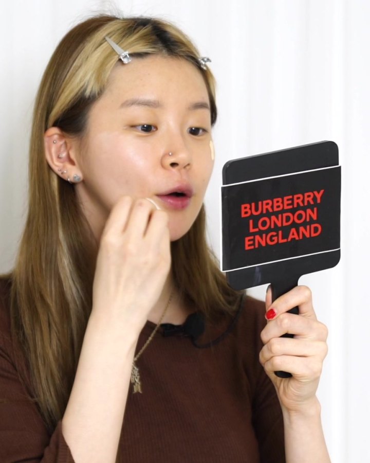 Minjeong dabbing foundation on with a misted makeup sponge